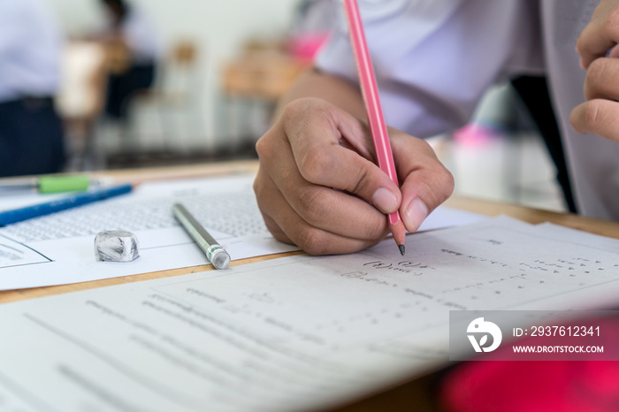 Students hands taking exams, writing examination room with holding pencil on optical form of standar