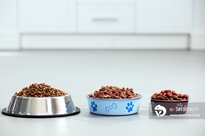 宠物食品放在地板上的金属碗里。