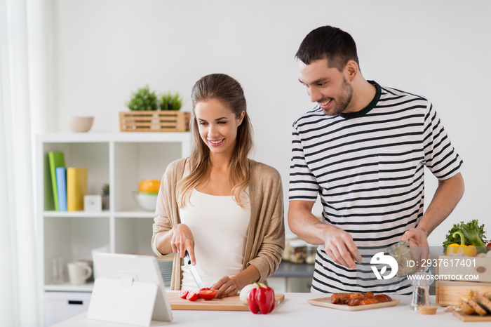 人与健康饮食理念-幸福夫妻用平板电脑在家烹饪食物