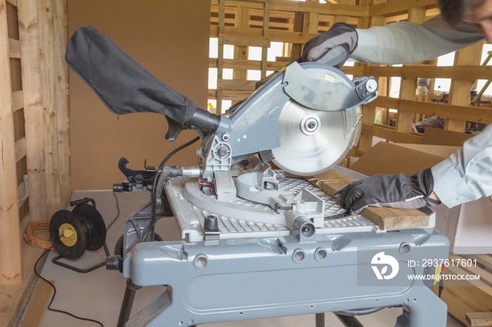 Portable circular saw and wood plank. Worker cuts a wooden board on Table Saw with Stand.