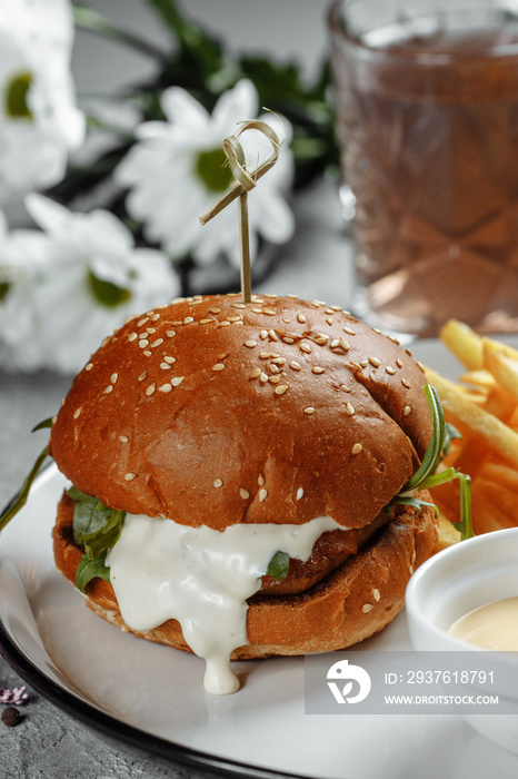 burger with fries and sauce on a white plate