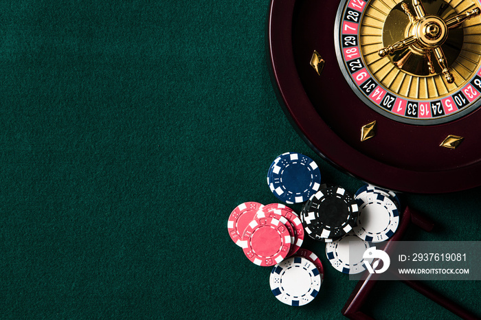 Roulette Wheel and Casino Chips on Green Table. Copyspace Background