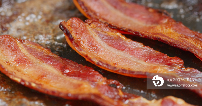 Fry bacon in pan in kitchen