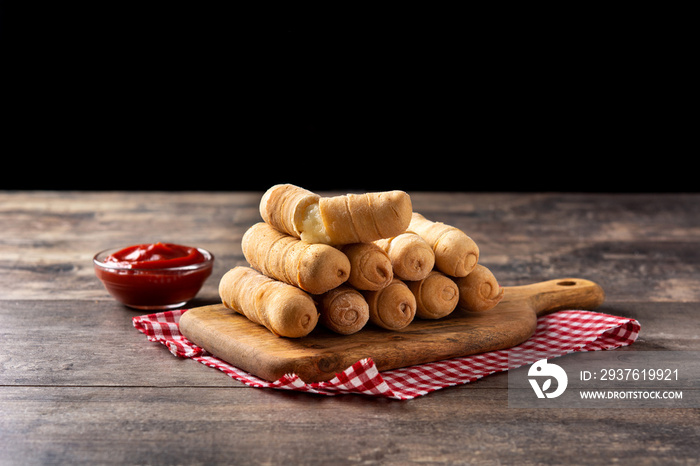 Latin American tequeños stuffed with cheese on wooden table