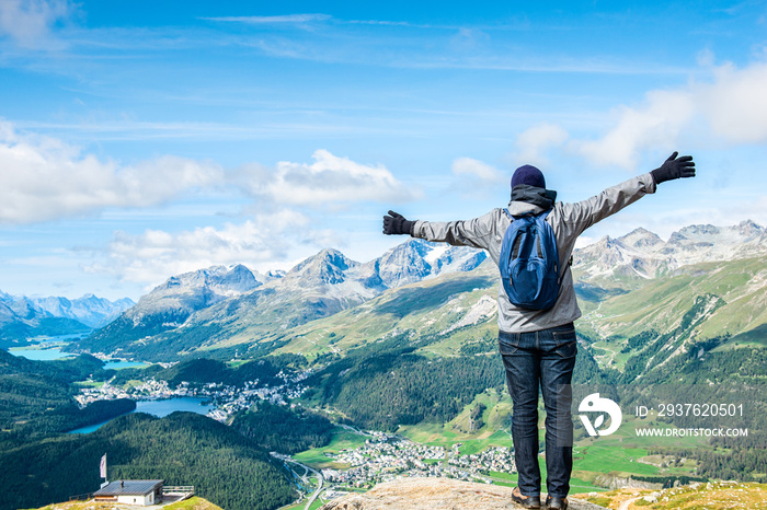 Young hiker standig front of the top of Piz da Staz and lakes in the area St.Moritz.