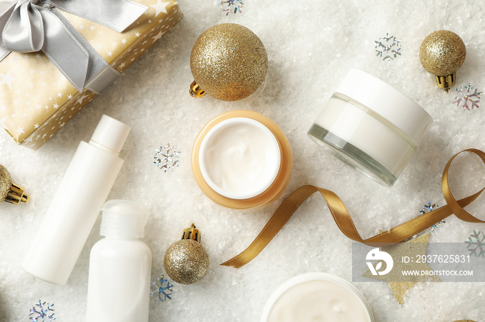 Concept of face care with cosmetics on background with decorative snow