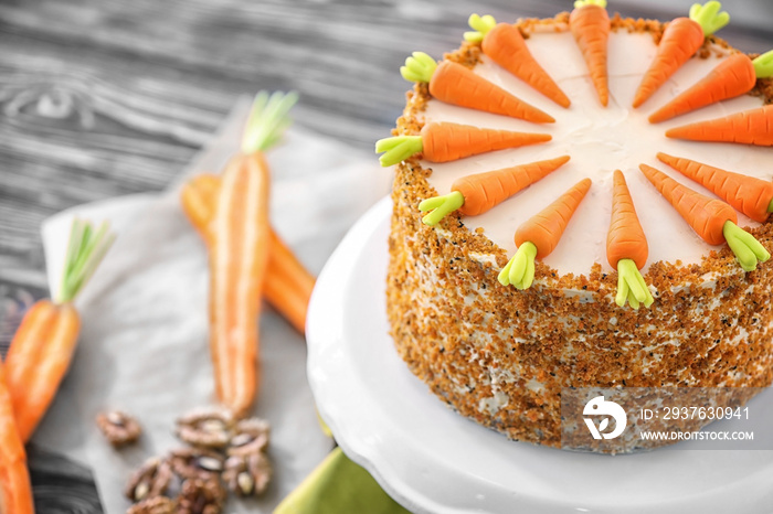 Stand with delicious carrot cake on wooden table