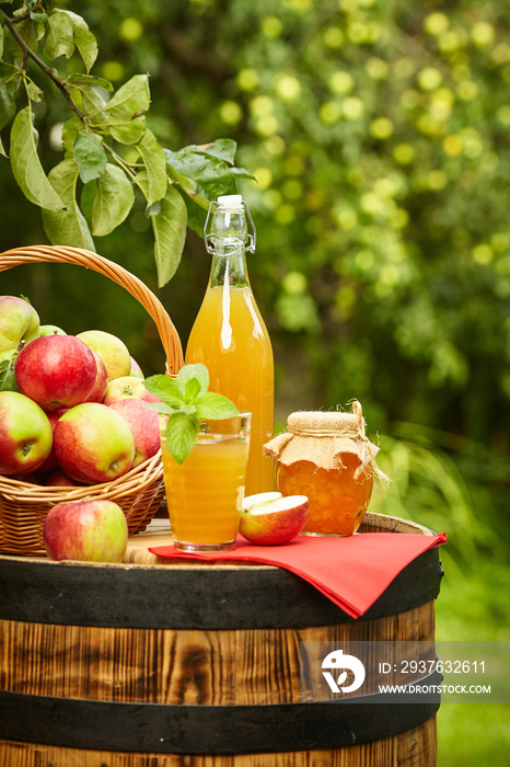 背景果园里的苹果站在桶上。苹果汁和苹果蜜冻。