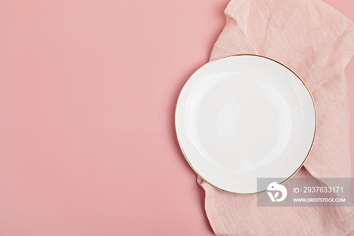 粉红色背景上的空白盘子和棉餐巾。菜单、食谱的食物背景。桌子