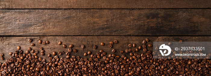 Coffee beans on wooden background with copyspace.