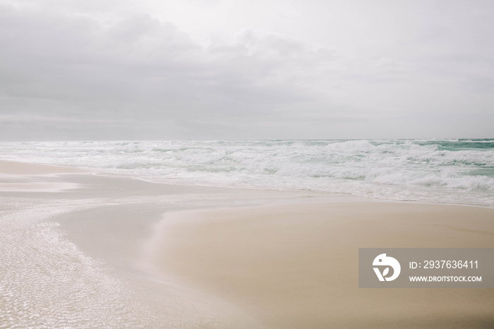 Beach with light blue water and white sand