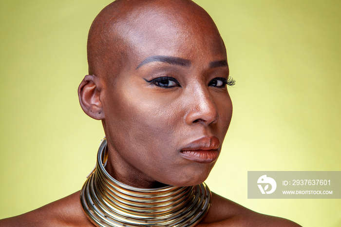 Studio portrait of woman wearing necking necklace against yellow background