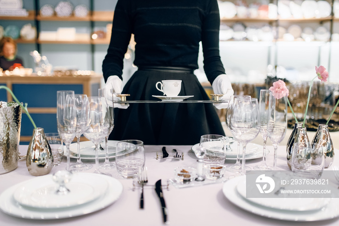 Waitress with tray puts the dishes, table setting