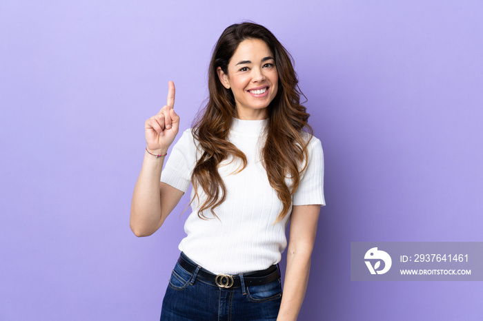 Woman over isolated purple background showing and lifting a finger in sign of the best