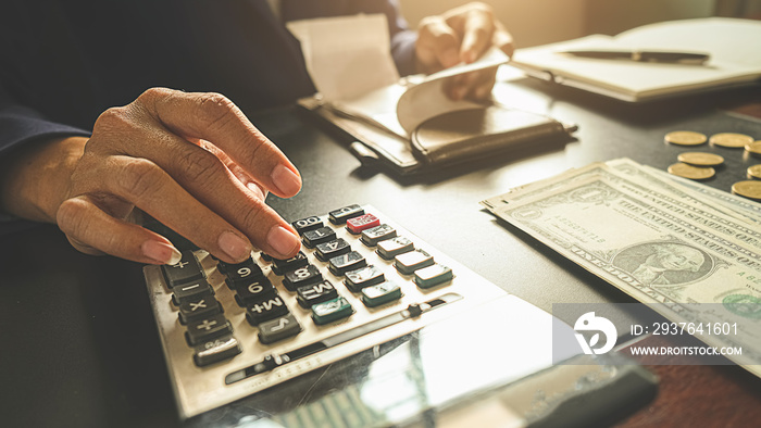 Woman with bills and calculator. Woman using calculator to calculate bills at the table in office. C