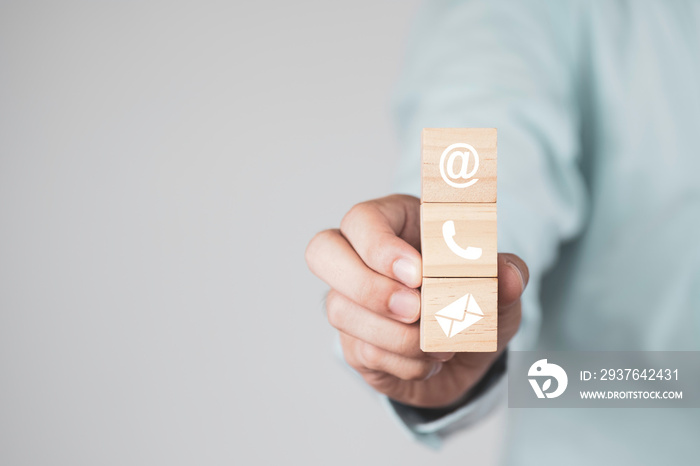 Businessman holding wooden cubes block which print screen Sign of e-mail , address and telephone for