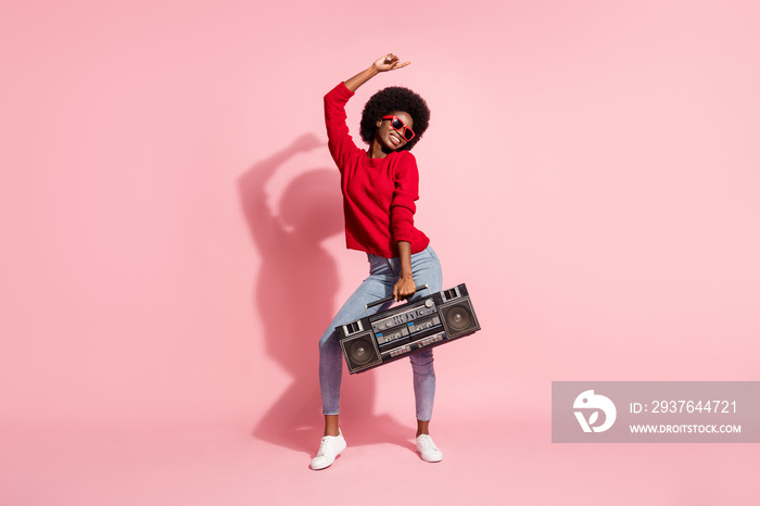 Full length photo of cool afro american pretty lady dance hold boombox isolated on pastel pink color