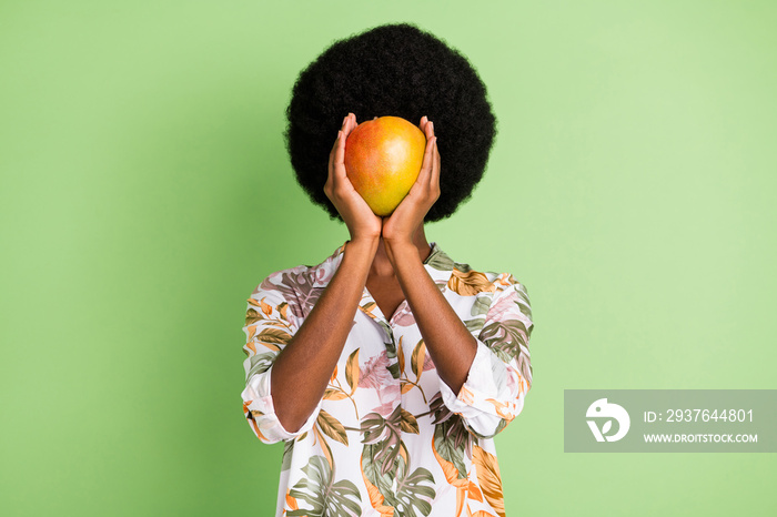 年轻黑人女孩近身封面水果芒果新鲜生态食品的照片，隐姓埋名地隔离在绿色之上