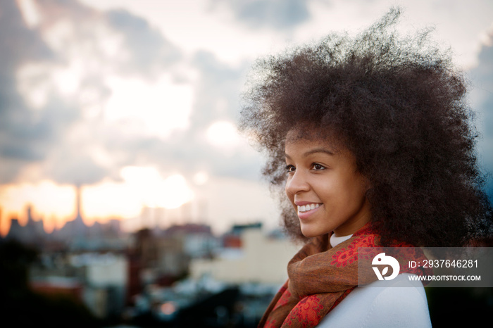 Young woman smiling, city in background