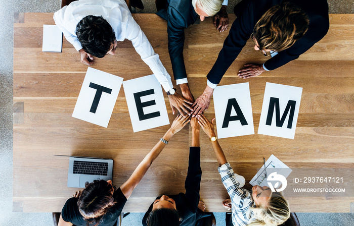 Team word on table with business people stacking hands