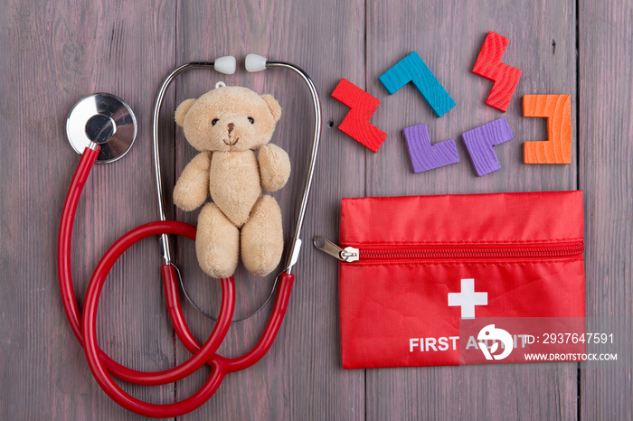 木制桌子上的小玩具熊、听诊器和急救箱——儿童保健概念，pe