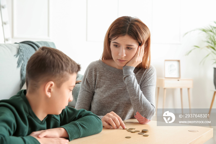 Sad mother with son counting alimony at home