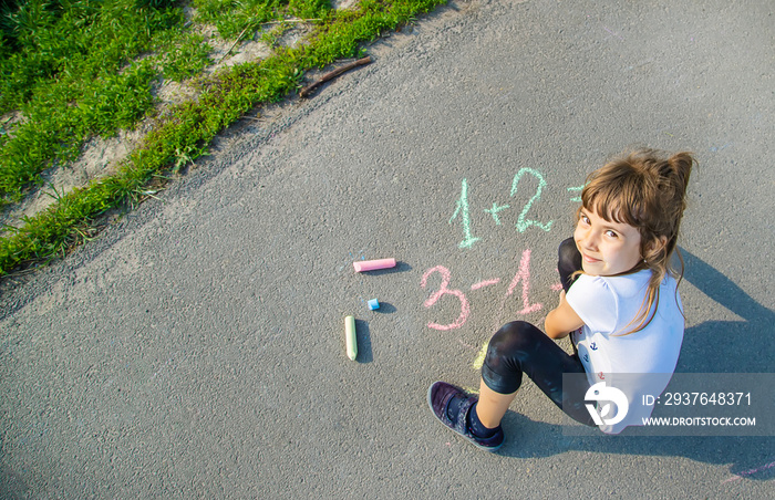 The child decides grunts on the asphalt. Selective focus.