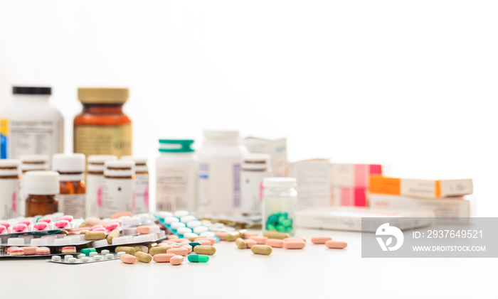 Stack of pills and containers on white background