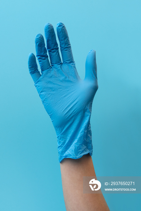 手戴蓝色背景的蓝色乳胶手套。流感、疾病、流行病和防护概念