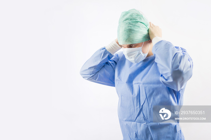 Surgeon doctor in sterile gloves preparing for operation in hospital. He is wearing surgical cap and