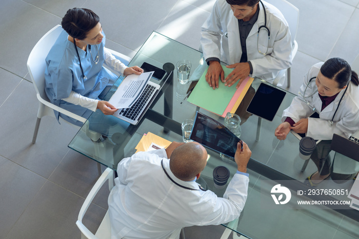 Medical team discussing with each other at the table in hospital