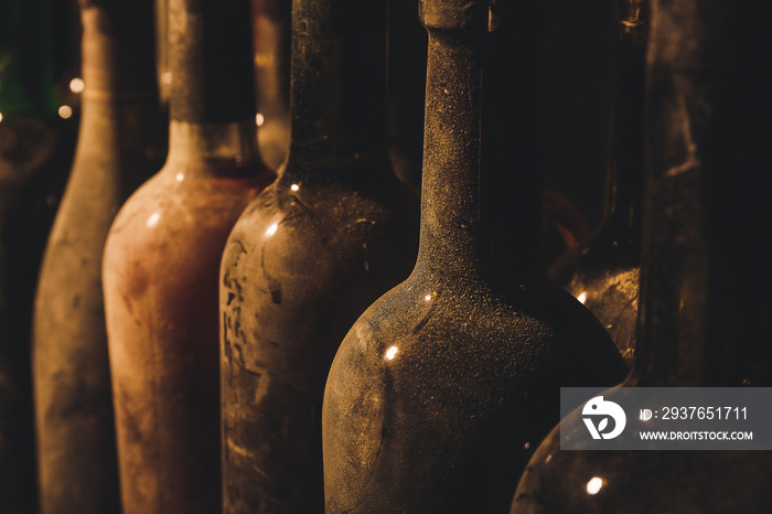 Bottles of wine in dark cellar, closeup