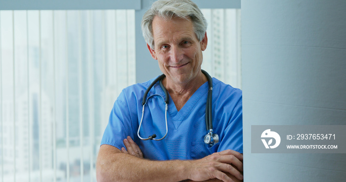 Portrait of smiling doctor or nurse in hospital with arms crossed. Happy senior male medical profess