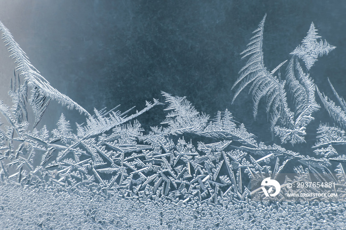 frosty patterns on the window glass closeup. Seasons of nature and uniqueness