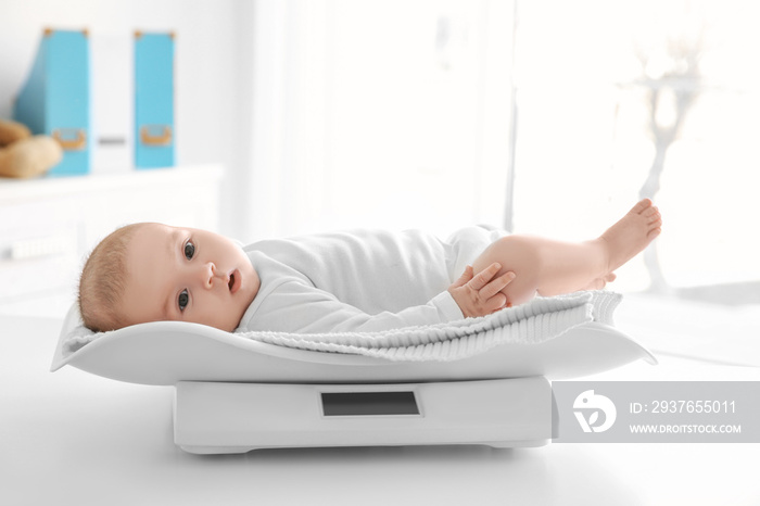 Cute little baby lying on scales in clinic