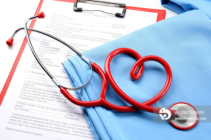 Red stethoscope and medical uniform with prescription, close up