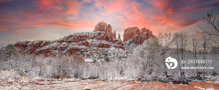 Sunset behind Cathedral rock, rising above fresh snow in the trees along Oak Creek in the red rock c