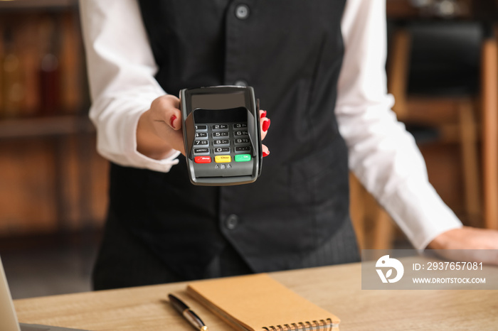 Waiter with payment terminal in cafe, closeup