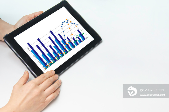 グラフが映っているタブレットの画面と手