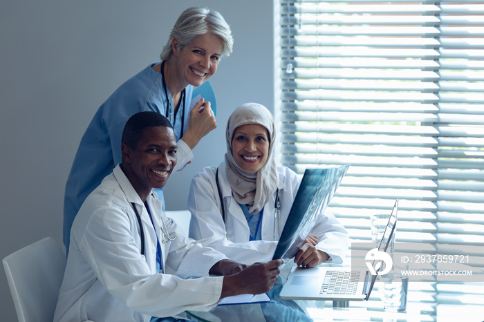 Happy medical team sitting on chair at hospital