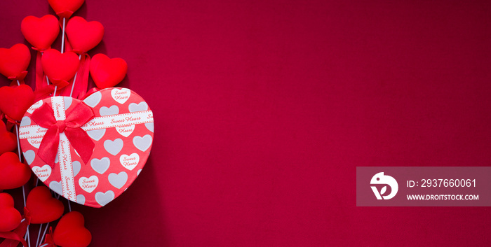 Gift box on red cloth. Red striped hearts