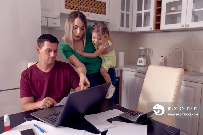 Worried parent calculating bills at home.