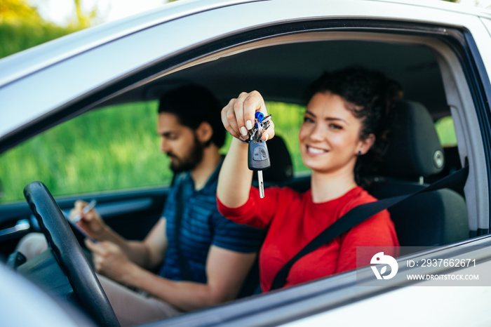 Driving school. Beautiful young woman successfully passed driving school test. She is sitting in car