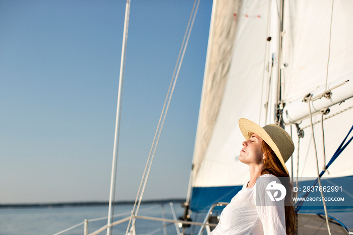 Woman sun-bathing on deck of sail boat