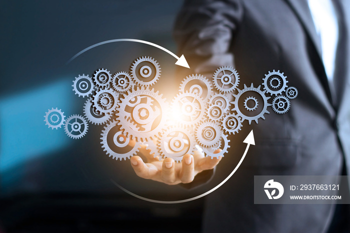 Business mechanism concept. Businessman holding with connected gears icons and business processes wo