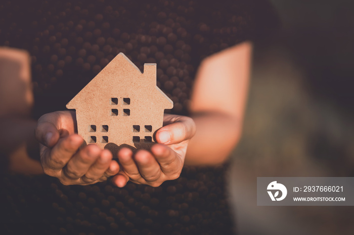 Small home model on woman hand.