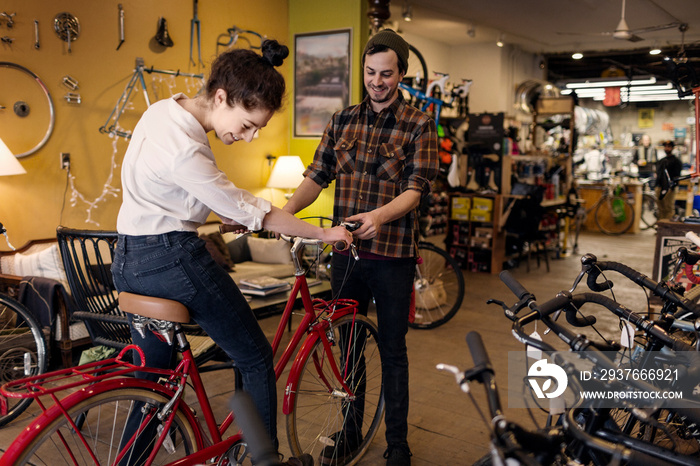 Customer talking with mid-adult man in bicycle shop