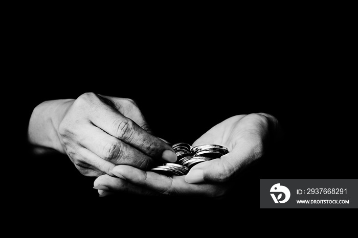 Money coin in hand black and white photo on black background - Black and white photo of coins in old