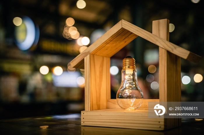 Light bulb with wood house on the table, a symbol for construction, Creative light bulb idea, power 