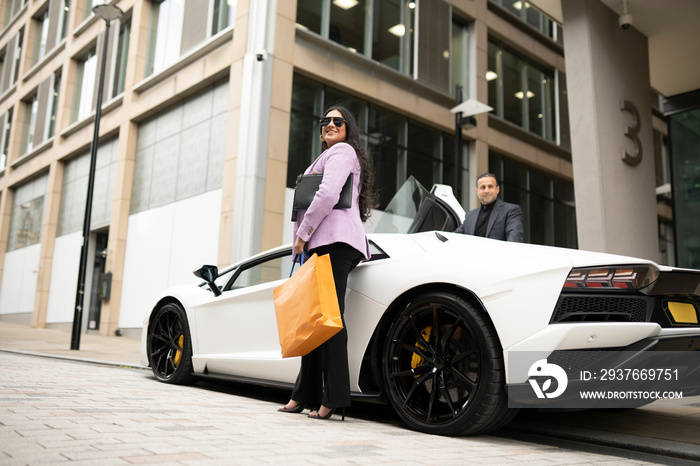 Father and adult daughter getting in luxury car